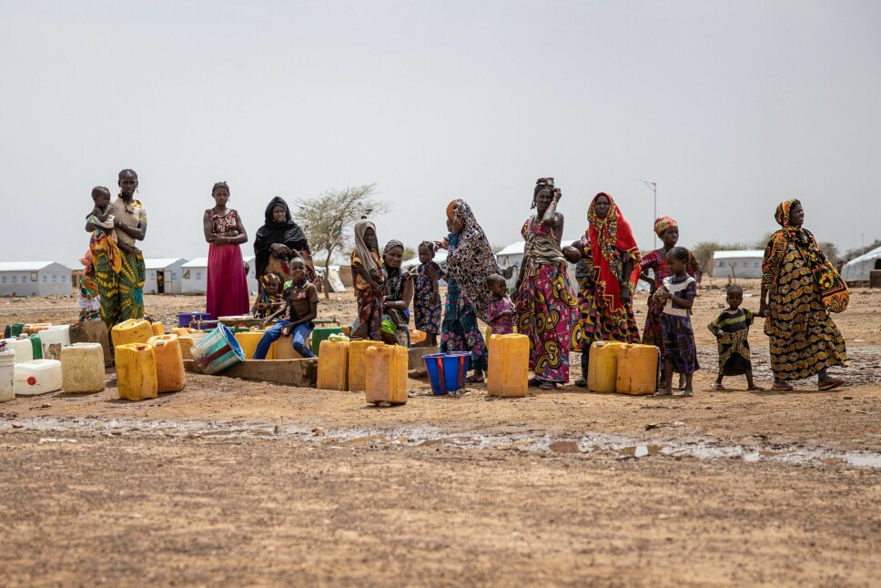 Kvinner står i kø ved vannpumpen i Goudebo-leiren, som tar imot tusenvis av maliske flyktninger i det nordlige Burkina Faso. I tillegg til å være et vertsland for flyktninger fra andre land, er ti prosent av Burkina Fasos egne innbyggere drevet på flukt.
