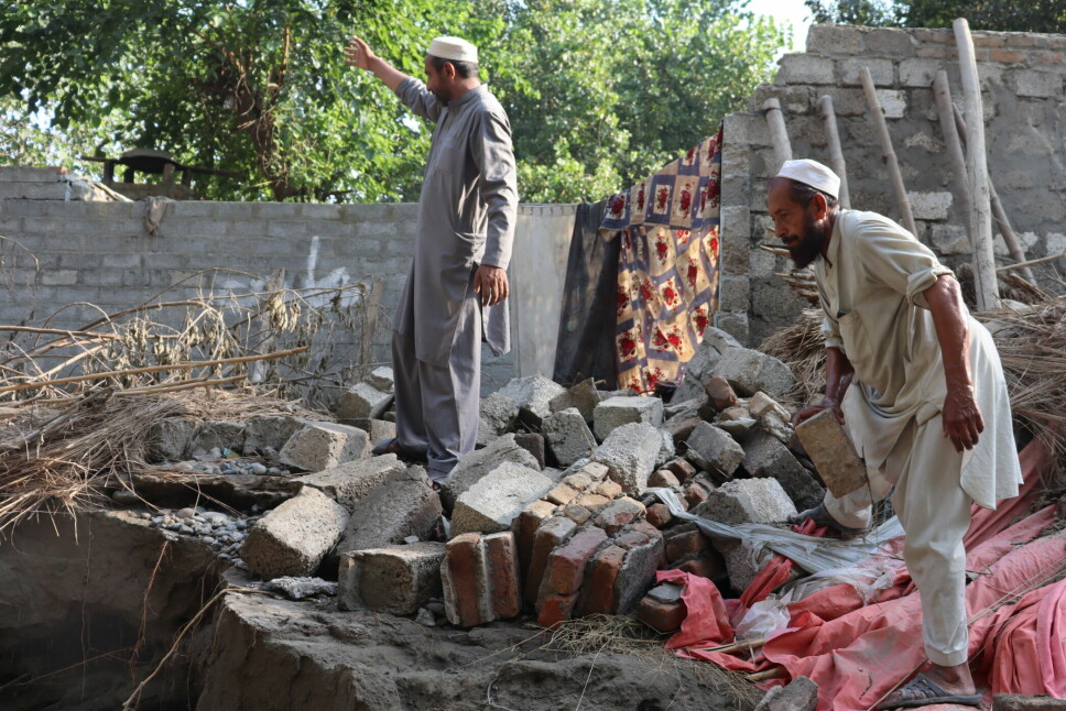 Tayeb Khan og hans nabo viser de gjennværende ruinene etter at flommen raserte nabolaget deres.