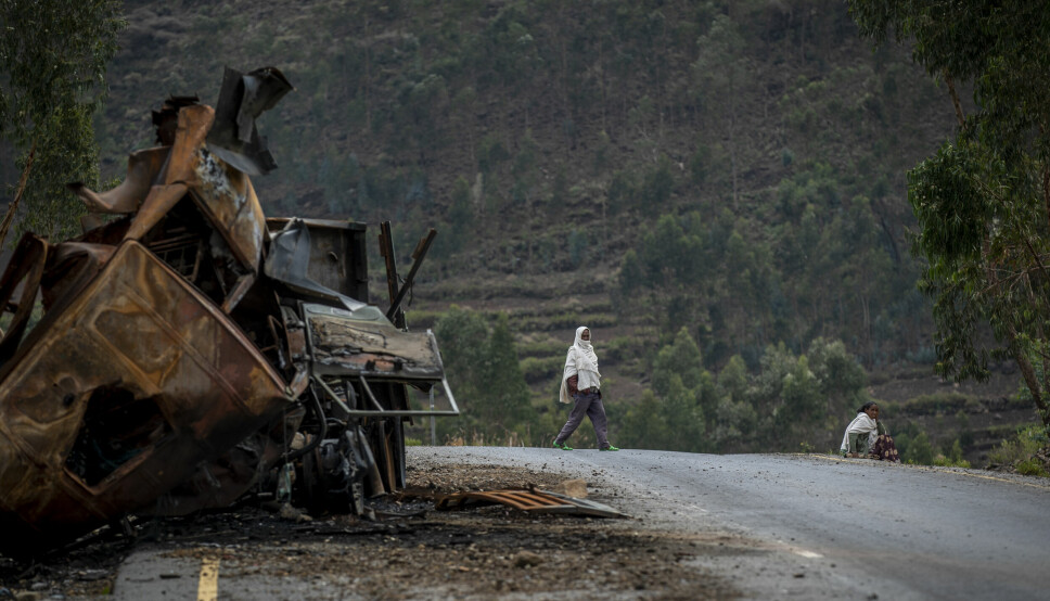 En mann går forbi en ødelagt lastebil på en vei mot byen Abi Adi i Tigray-regionen i fjor. Myndighetene i regionen hevder at Eritrea har satt inn store styrker i konflikten som nå har pågått i snart to år.