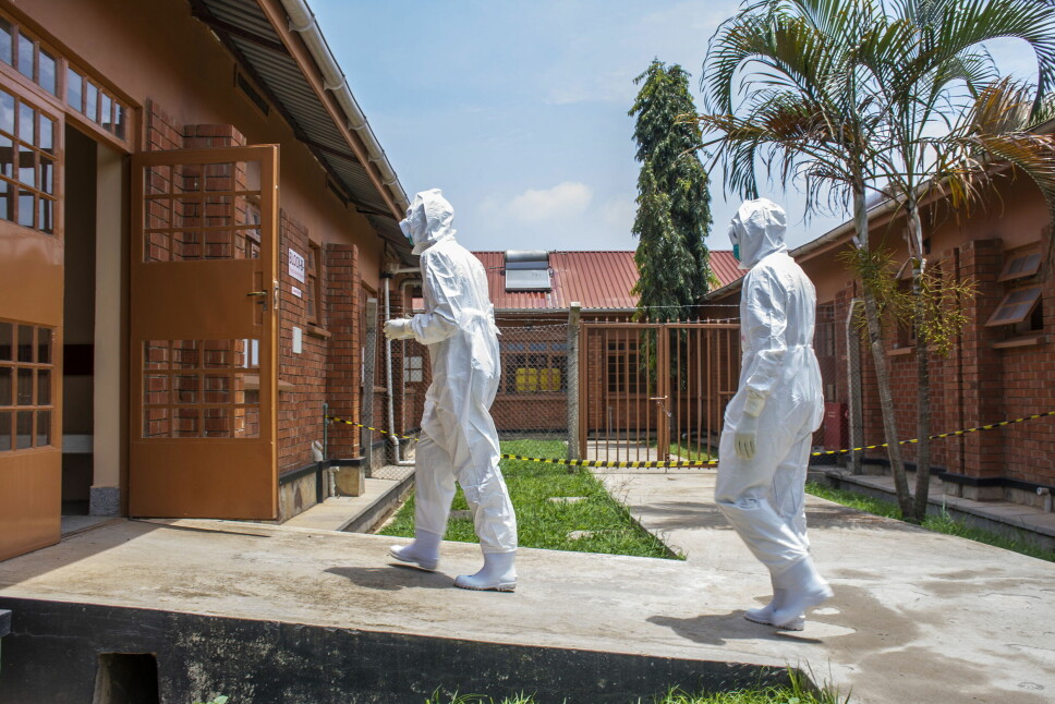 Ugandiske leger kledd i verneutstyr er på vei inn til isolasjonsenheten ved Entebbe Regional Referral-sykehuset i Entebbe. De siste dagene er 14 nye tilfeller oppdaget i hovedstaden Kampala.
