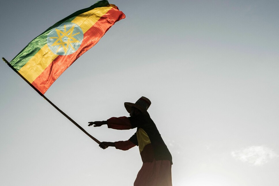 En mann vifter med et etiopisk flagg under en demonstrasjon til støtte for Etiopias væpnede styrker i Addis Abeba 22. oktober i år. Denne uken avholdes det formelle fredssamtaler mellom partene i Pretoria, noe som gir et svakt håp om fred