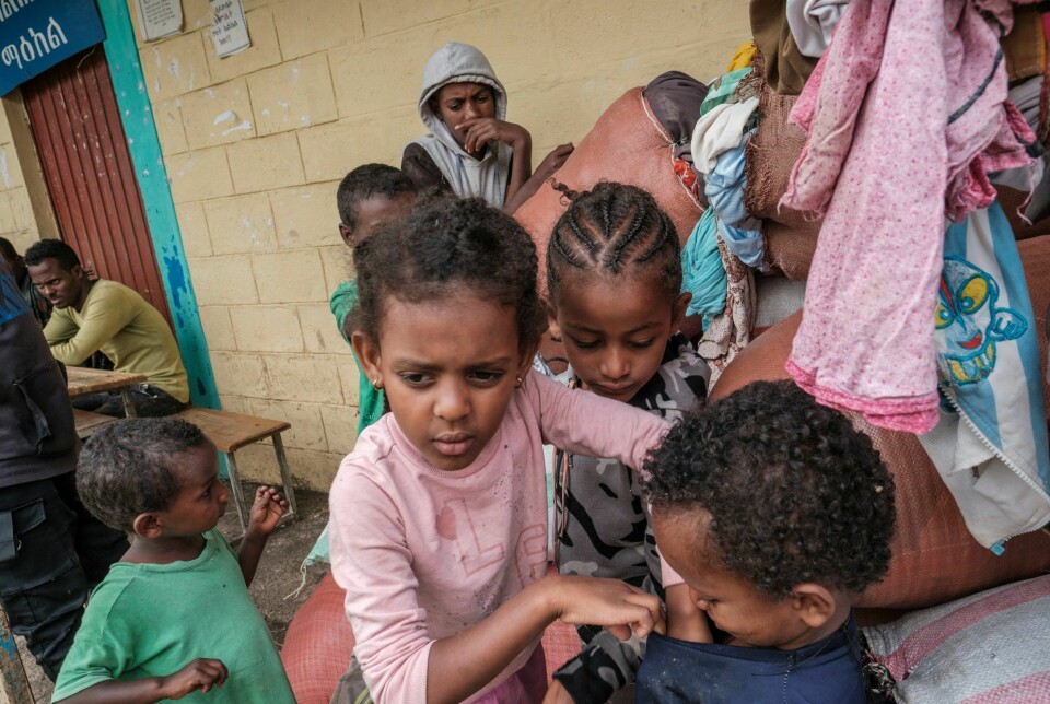 Barn som har flyktet fra krigen leker blant sekker av klær på en skole i byen Dessie i Amhara-regionen i august 2021.
