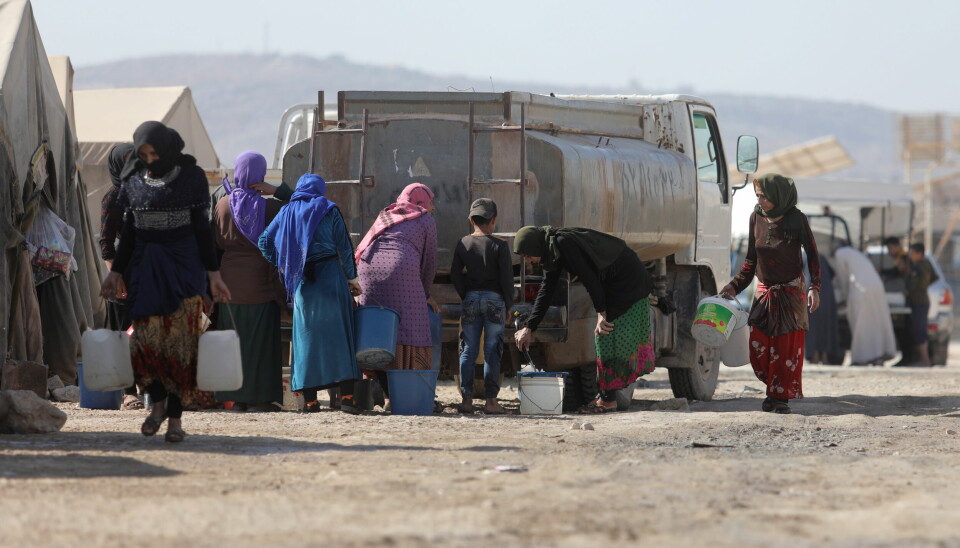 Syriske flyktninger fyller vann fra en tank ved Kalbeet-leiren, som ligger nord i landets Idlib-provins. 14,6 millioner syrere har behov for humanitær bistand.