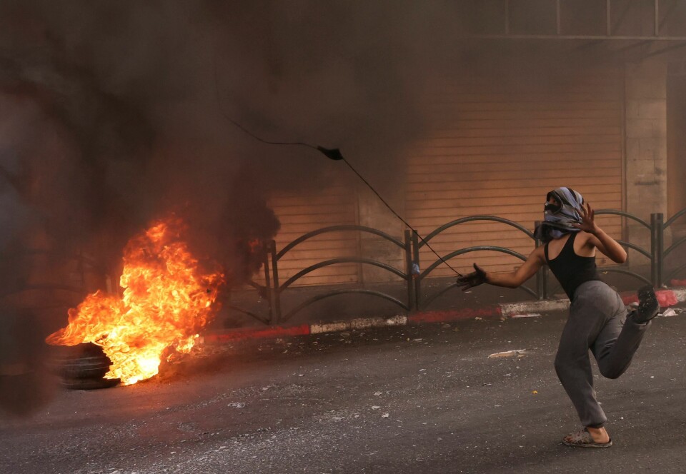En palestinsk demonstrant bruker et slengskudd for å kaste stein mot israelske sikkerhetsstyrker under konfrontasjoner i sentrum av den okkuperte byen Hebron på Vestbredden 14. oktober i fjor. Foto: Hazem Bader / AFP / NTB