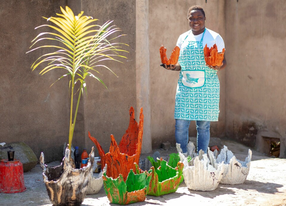 Memory Makala (25) viser frem blomsterpotter hun har laget av brukte klær i Blantyre, Malawi. Makala er en av mange unge i det østafrikanske landet som har laget egne jobber for å livnære seg. Foto: Joseph Mizere / Xinhua / NTB