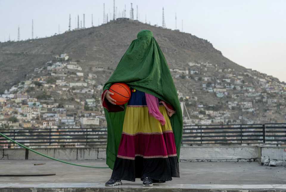 En afghansk kvinne stiller til fotografering med en basketball i Kabul. Siden desember har det vært forbudt for kvinner å drive med idrett i Afghanistan. Foto: Ebrahim Noroozi / AP / NTB