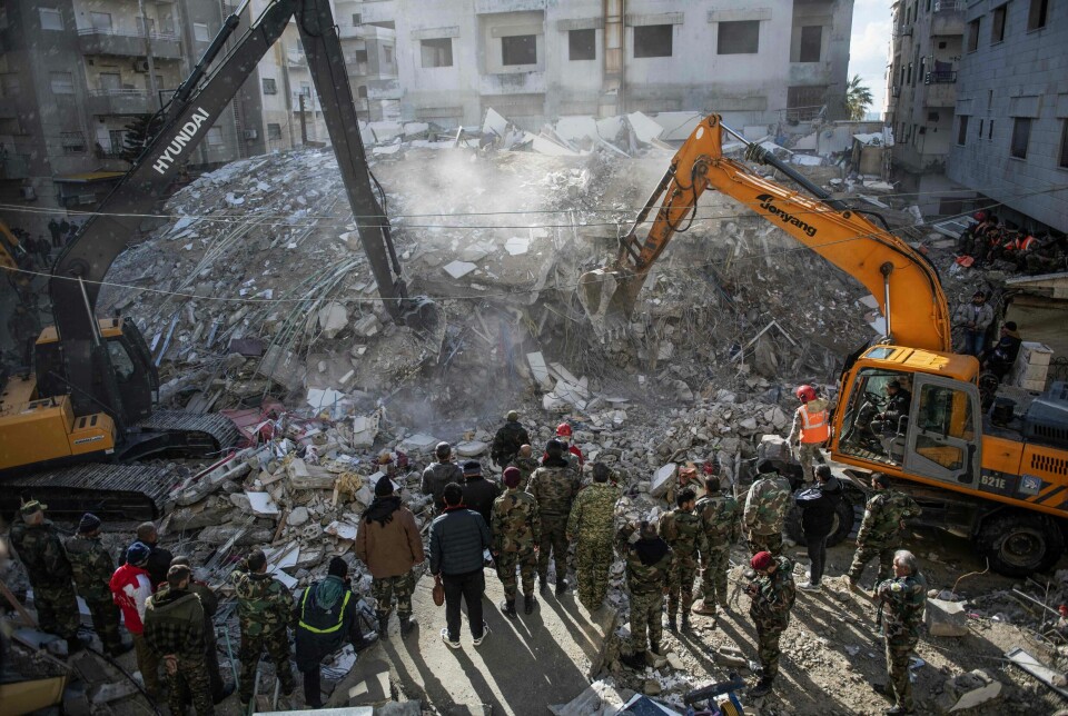Redningsarbeidere leter etter overlevende i ruinene av en kollapset bygning i byen Jableh i Syrias nordvestlige provins Latakia. Nå gir Norge 150 millioner kroner til de jordskjelvrammede områdene i Syria og Tyrkia – og utelukker ikke at det kan bli mer. Foto: AFP / NTB