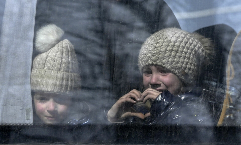 Ei jente viser et hjerte med hendene gjennom et bussvindu idet sivile blir evakuert fra byen Mariupol 24. mars i fjor. Byen var da allerede kontrollert av russiske og russiskstøttede styrker. Foto: Pavel Pavlov / Anadolu Agency / NTB