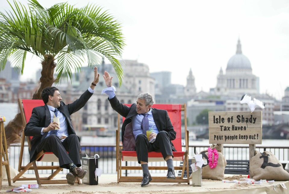 To demonstranter mot skatteparadiser kledde seg ut som en forretningsmenn i London i forkant av G8-toppmøtet 2013. Skatteparadiser er geografiske områder hvor utenlandske personer og bedrifter ikke betaler skatt eller lite skatt, ofte med mangel på innsynsmuligheter. Foto: Justin Tallis / AFP / NTB