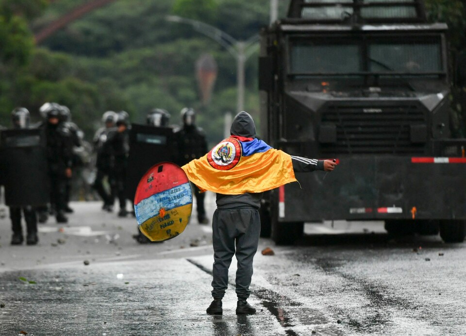 En demonstrant møtte opprørspoliti i Medellin, Colombias nest største by, under en protest mot myndighetene i 2022. Foto: Joaquin Sarmiento / AFP / NTB