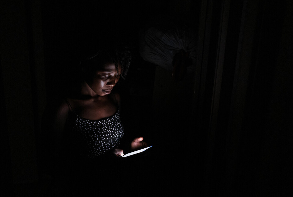 – Jeg vil ikke at familien min skal få vite hvor ille det er her, sier Salimato (19). Det eneste lyset de har i leiligheten etter at det er blitt mørkt, er lyset fra mobilen.