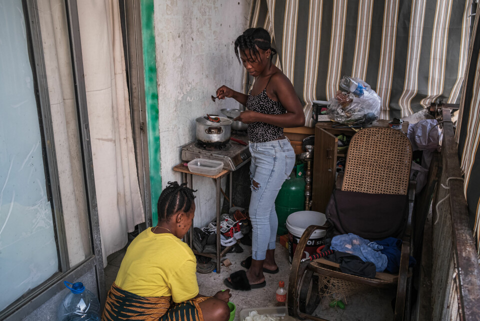 19 år gamle Salimato og 22 år gamle Zainab (i gult) fra Sierra Leone låner det provisoriske kjøkkenet på balkongen til naboen.