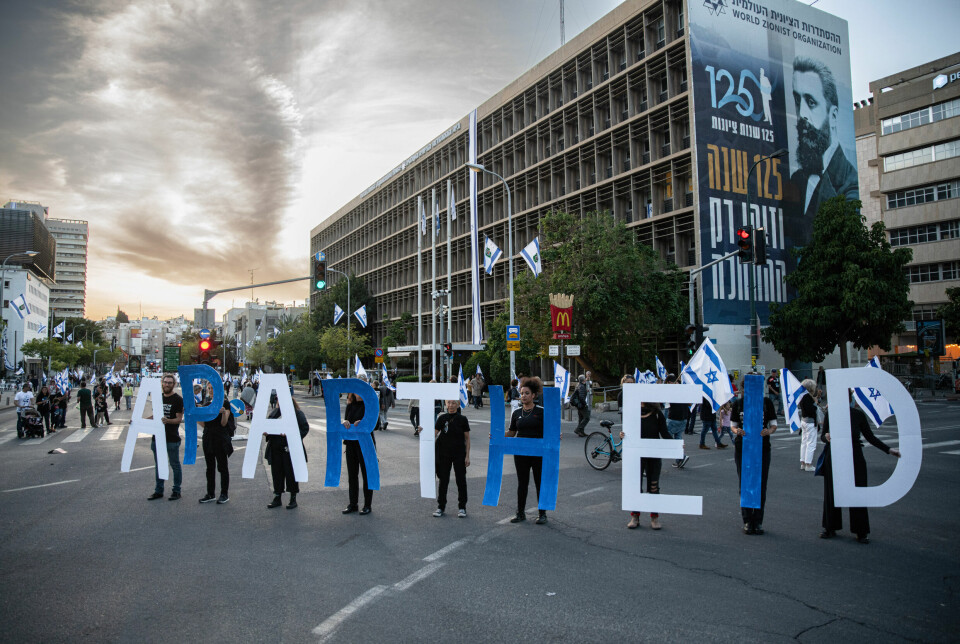 Demonstranter markerer 75-årsdagen ved siden av et skilt med Theodor Herzl-bilde under en demonstrasjon i Tel Aviv 22. april.