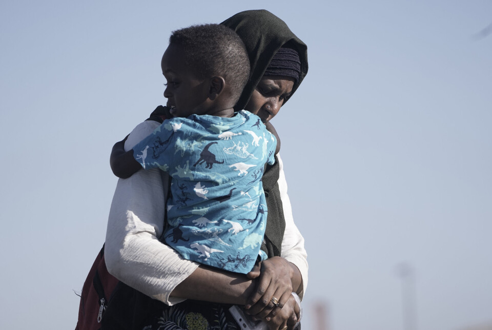 En kvinne på flukt bærer sønnen sin. I følge FN er rundt to millioner mennesker drevet på flukt fra Sudan, bare siden april i år.