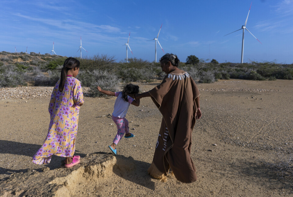 Denis Velásquez Uriana, a traditional Malui authority, plays with his niece and granddaughter outside the family cemetery located 500 meters from the Guajira 1 wind farm. Of the 10 wind turbines that make up the wind farm, seven are located on its territory, however the company did not take them into account during prior consultations.