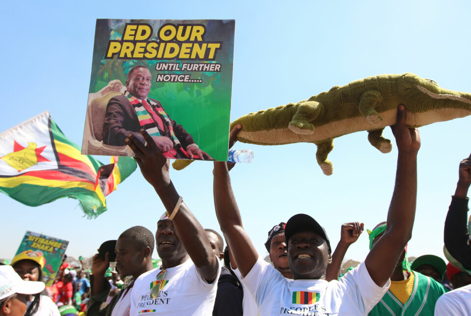 På et valgmøte i Harare holder ZANU-PF tilhengerne opp plakater til støtte for presidenten, og en lekekrokodille som spiller på Mnangagwas kallenavn 'krokodillen'.