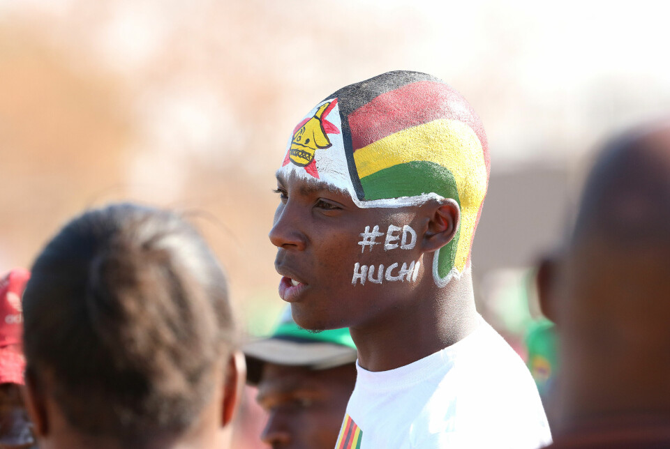 En ZANU-PF tilhenger har malt hodet med det zimbabwiske flagget, og skrevet #ED HUCHI på ansiktet. Det betyr at Emmerson Dambudzo Mnangagwa er som honning.
