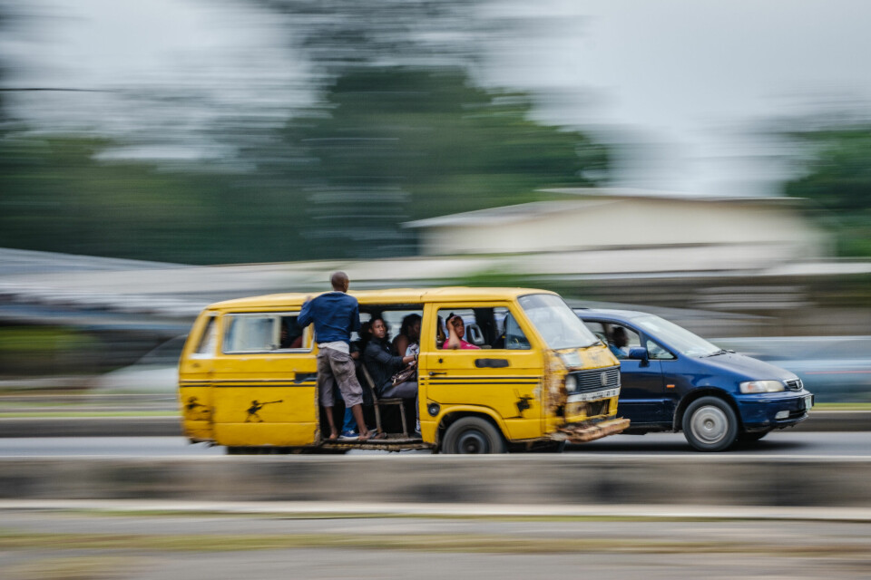 En «danfo» suser gjennom Lagos. Danfo-bussene er en viktig del av hverdagen til dem som bor her, og frakter millioner av mennesker rundt i byen hver dag.