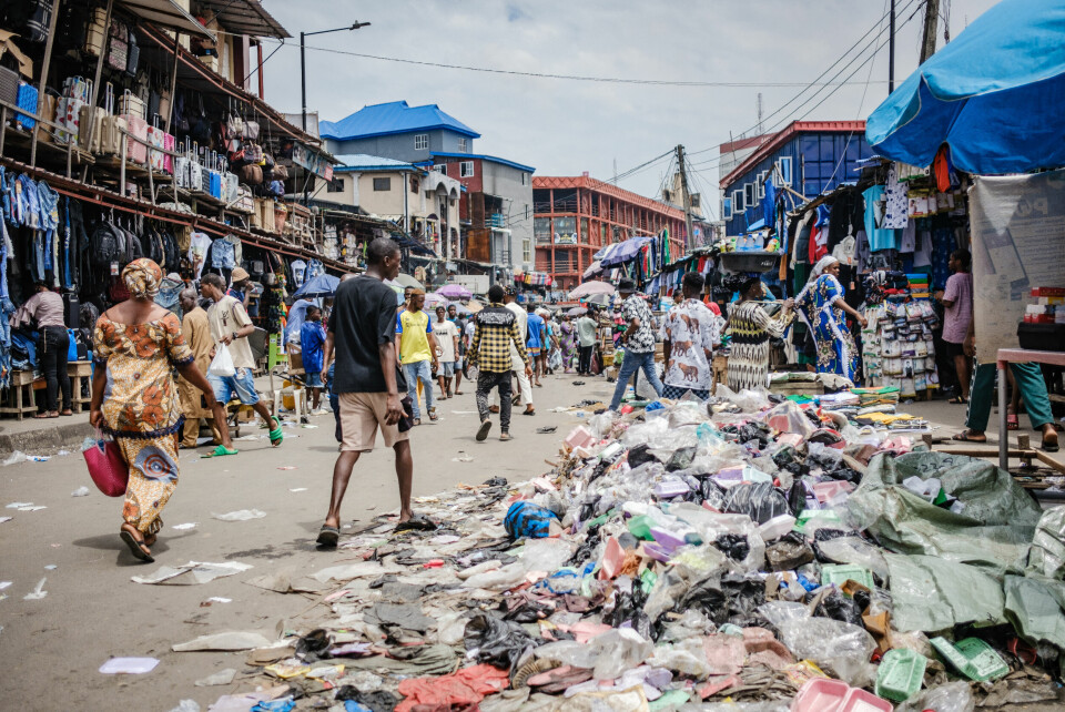 LAGOS, NGA - June 9, 2023: People walk past a dump area in Balogun market, Lagos Island, Nigeria. Waste management is a big concern in Lagos metropolis, a big call for climate action. CREDIT: Taiwo Aina