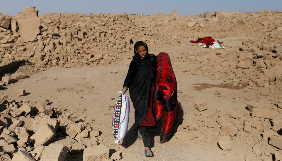 En afghansk kvinne bærer med seg en madrass og en pute i en landsby som heter Chahak i Herat-provinsen vest i Afghanistan. Herat ble rammet av et nytt jordskjelv i morges, bare dager etter at et annet skjelv rammet Herat.