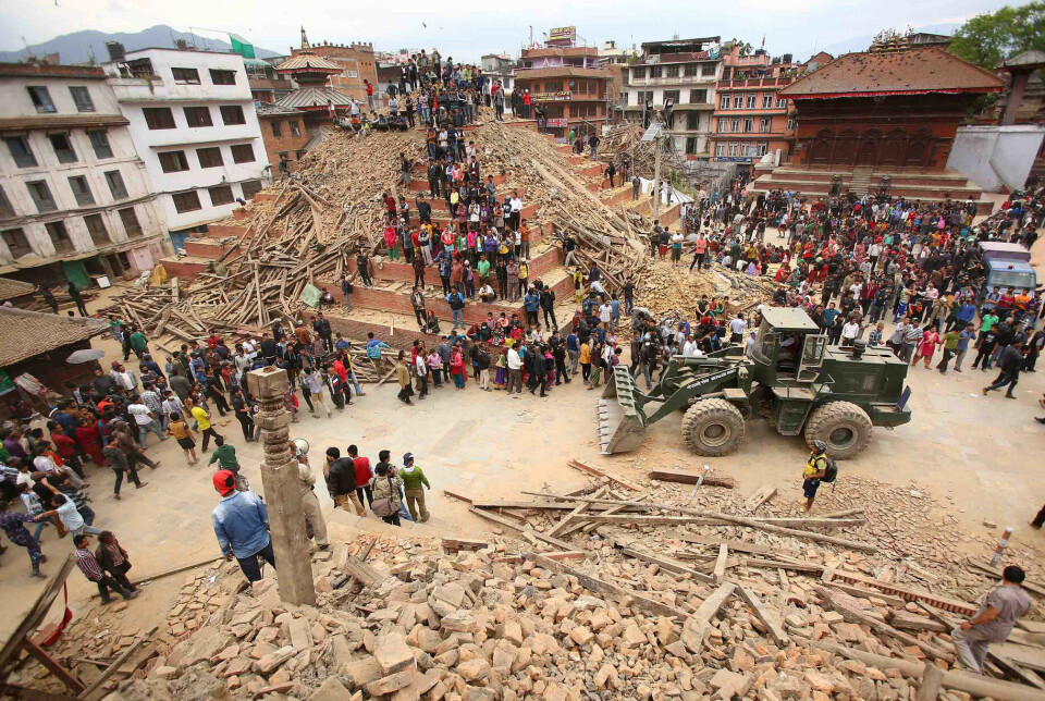 Redningsarbeidere og innbyggere samles rundt restene av et tempel i Kathmandu etter det kraftige jordskjelvet Nepal i april 2015.