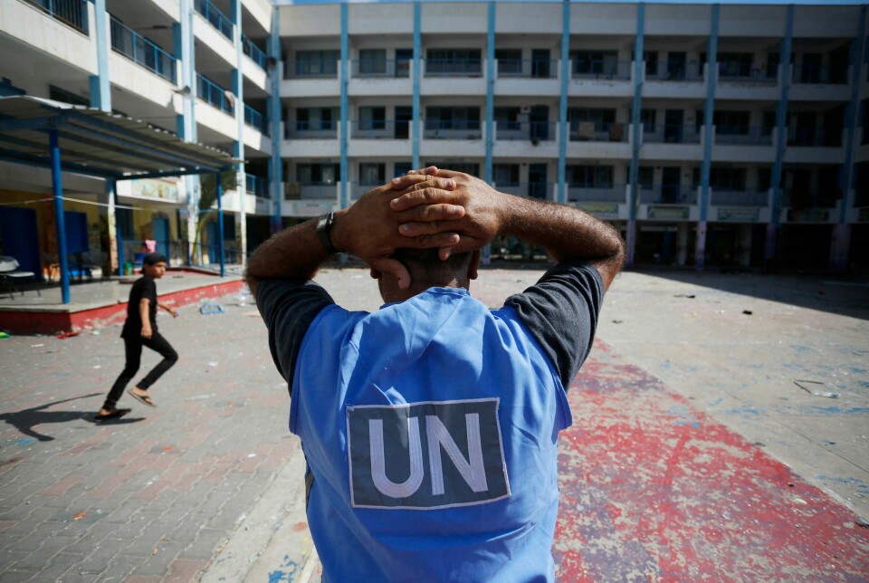 En FN-frivillig holder seg til hodet i skolegården til den FN-drevne skolen i Al-Maghazi-flyktningleiren i Gaza . Seks personer skal ha blitt drept i i et angrep på skolen, blant annet flere ansatte i UNRWA. FN er en av flere store organisasjoner som jobber i Palestina under svært vanskelige forhold.