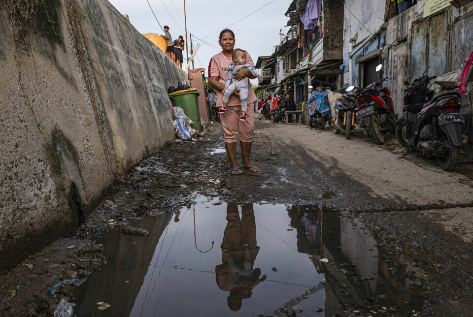 Da Emi var ung jente, lå nabolaget hennes i Jakarta over havnivået. Nå ligger nabolaget under havnivået. Hun og datteren bor rett ved en betongmur på over to meter som hindrer av havvannet fosser inn.