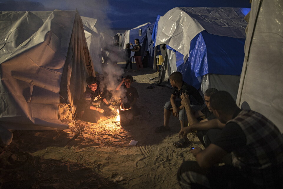 Gaza har vært uten strøm siden 11. oktober. Her varmer internt fordrevne palestinere seg rundt et bål i en leir satt opp av FNs utviklingsprogram (UNDP) i Khan Younis 31. oktober 2023.