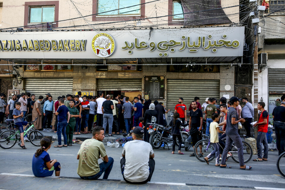 Folk står i kø for å kjøpe brød utenfor et bakeri i Khan Younis, sør i Gaza 15. oktober 2023.