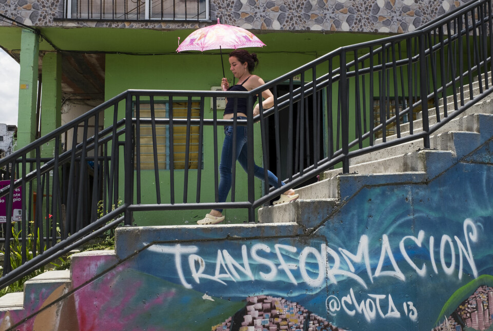 En kvinne skynder seg ned de nye trappene i bydelen Comuna 13.