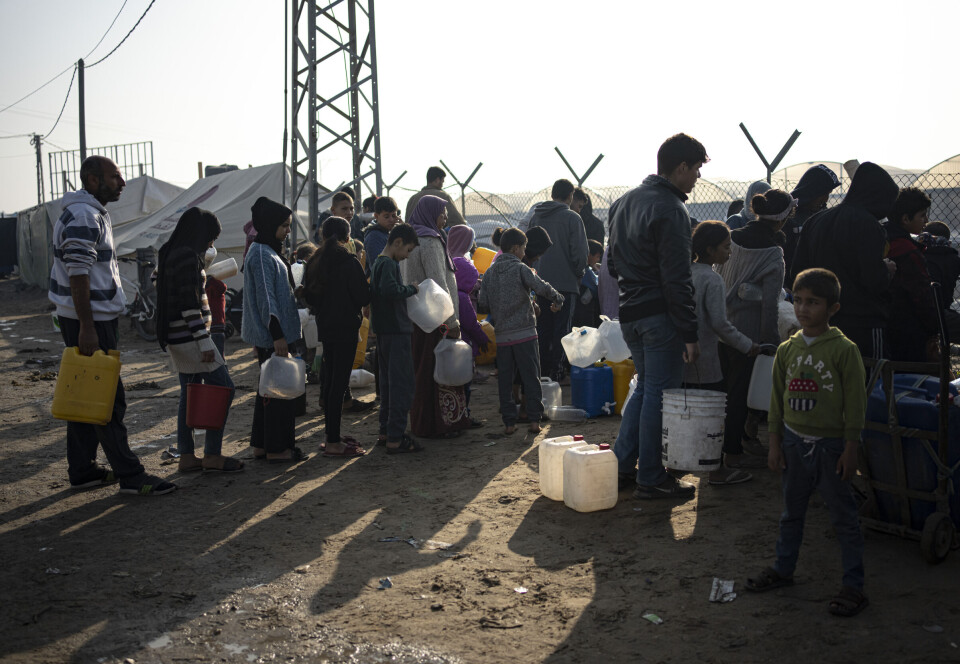 Medlemmer av Abu Jarad-familien står i kø for vann ved en provisorisk teltleir i Muwasi-området, sør i Gaza.