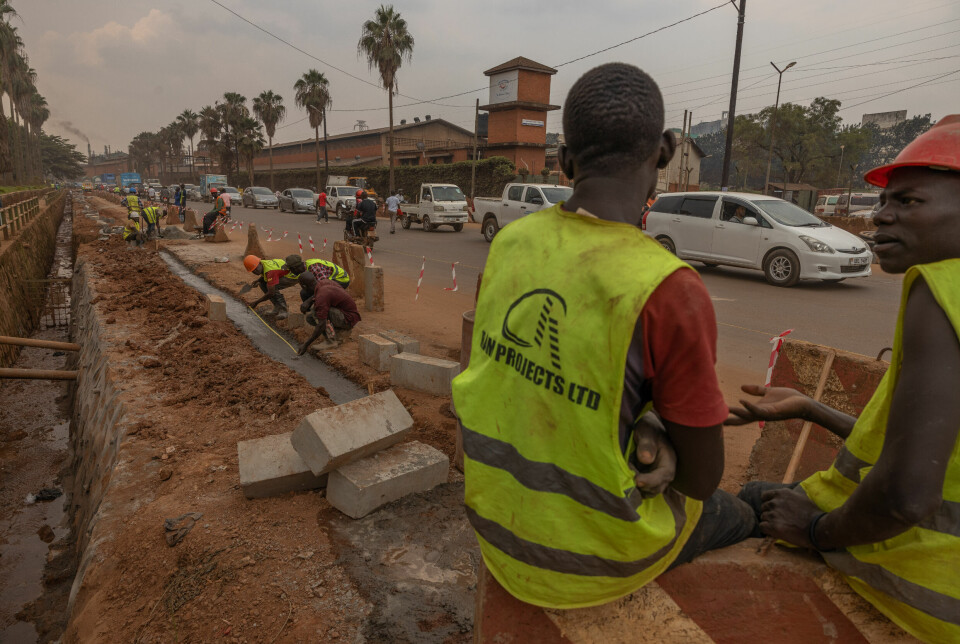 To arbeidere tar seg en pust i bakken. Ved den viktige hovedveien Jinja road pågår arbeidet med å lage en bredere vei og rydde kloakksystemet langs veien for fullt.