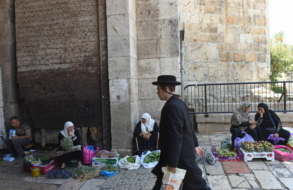En ultraortodoks jøde passerer palestinske kvinner som selger produkter ved Damaskus-porten i gamlebyen i Jerusalem.