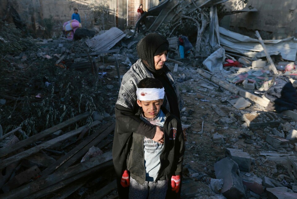 En palestinsk kvinne omfavner en skadet gutt i ruinene til en bygning i Rafah på Gazastripen.