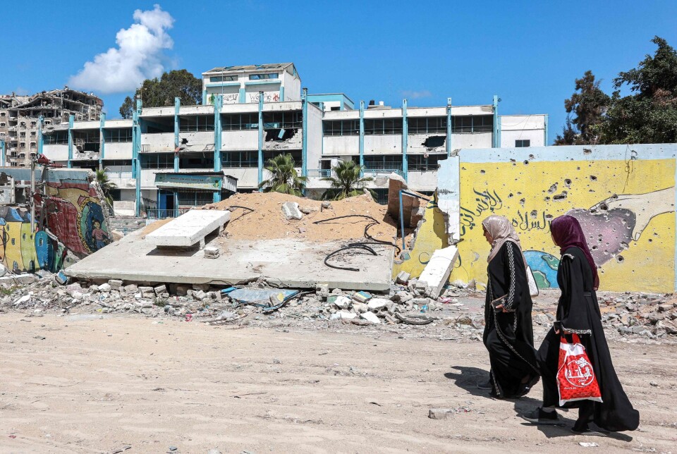 To palestinske kvinner passerer det som er igjen av en UNRWA-drevet gutteskole vest for Gaza by.
