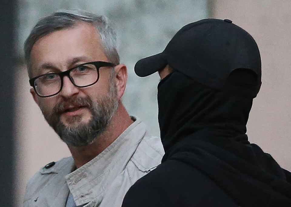 Den krimtatariske rettighetsaktivisten Nariman Dzhelyalov blir eskortert inn i en politbil av en russisk soldat under rettssaken i 2021. Dzhelyalov ble anklaget for medvirkning til sabotasje av en gassrørledning og dømt til 17 års fengsel.