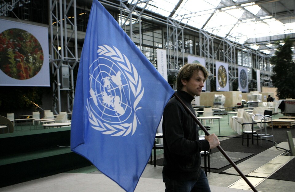 – Det er en ulempe med få norske FN-ansatte når verden står i en verdikamp, som også har internasjonale organisasjoner som arena, skriver Tormod Nuland. Bildet viser en arbeider som bærer FN-flagget på FNs klimakonferanse i Danmark i 2009.