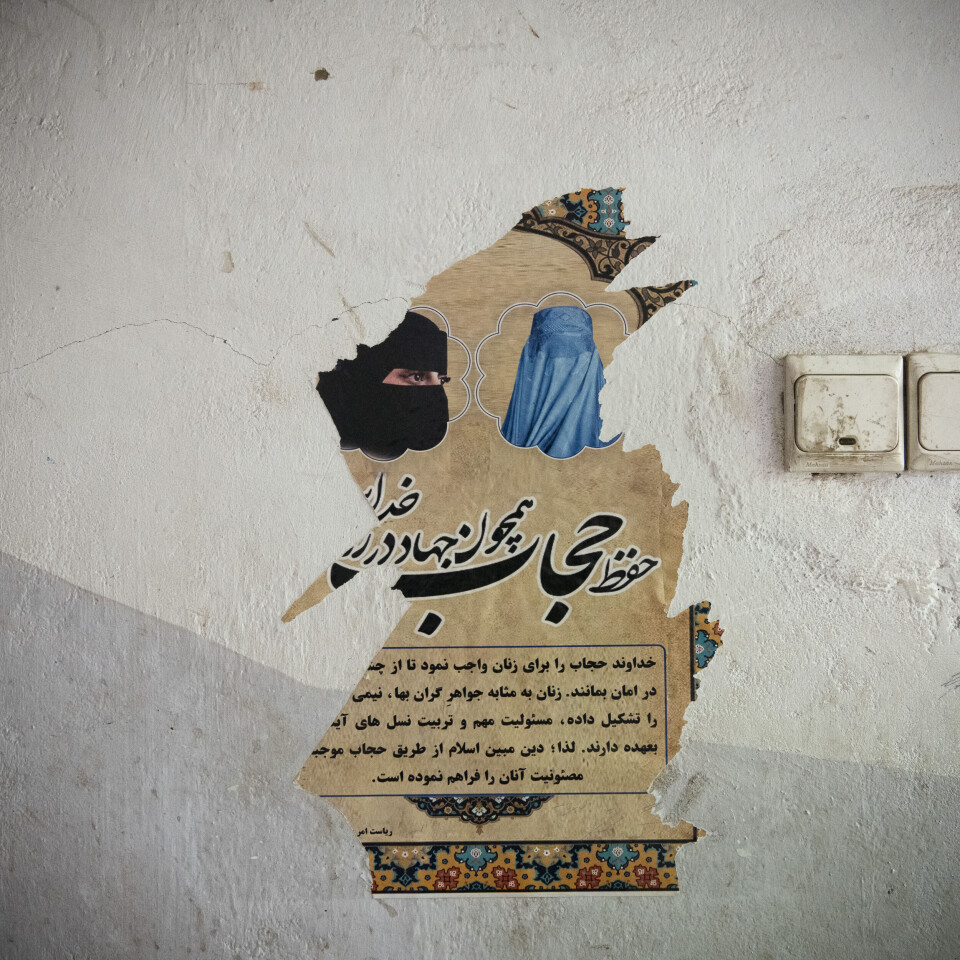 Restene av en plakat viser hvordan kvinner skal dekke til ansiktet: med burka eller chadari, et heldekkende hodeplagg, eller med niqab, der bare øynene er synlige.