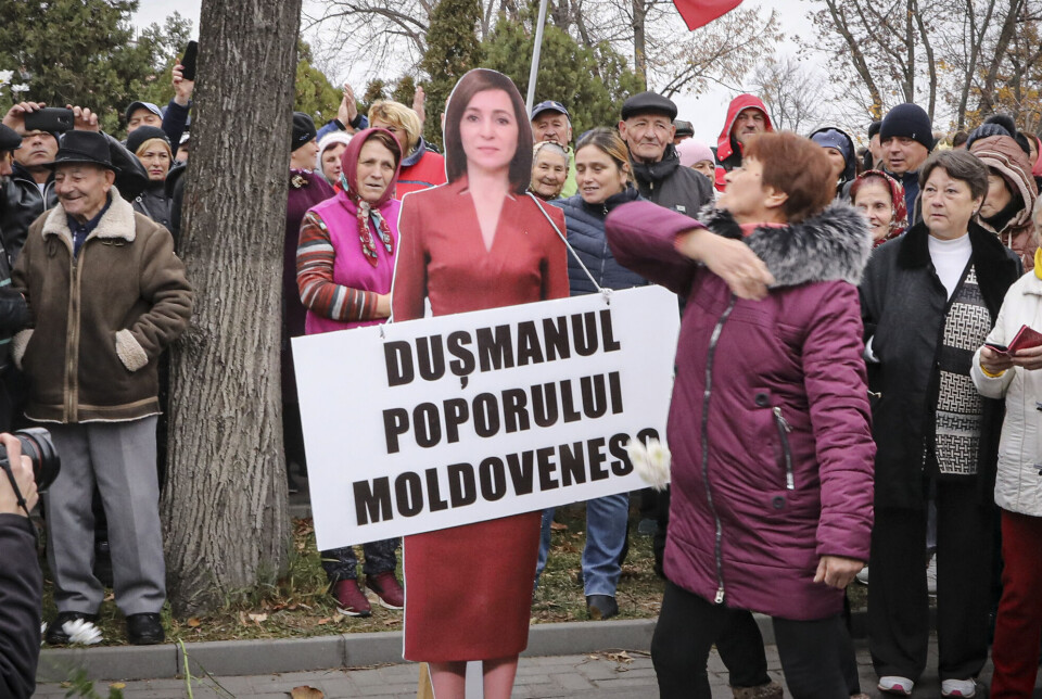 En kvinne klapper til en pappfigur av president Maia Sandu under en protestaksjon initiert av det prorussiske populistiske partiet Shor høsten 2022. Demonstrantene demonstrerte mot prisstigningen og krevde presidemntens avgang.