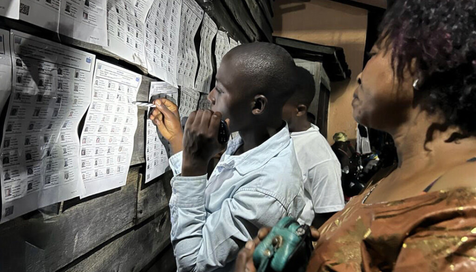 Folk som skal stemme leser informasjonen utenfor et valglokale i DR Kongo under valget i 2023.
Norge og flere andre giverland bruker årlig mye
bistandspenger
på å
støtte
opp under demokratiet globalt,
blant annet
ved å støtte valgprosesser. Men forskere er uenige om hvorvidt vi vet om slik bistand virker eller ikke.