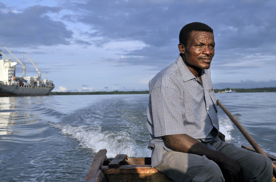 En lokal fisker kjører båten forbi store lasteskip utenfor havnebyen Buenaventura på Colombias stillehavskyst.