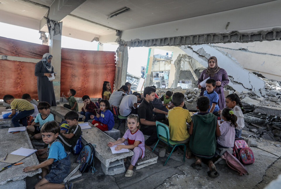 Frivillige lærere underviser barn i et ødelagt klasserom på Tabariya-skolen i Khan Yunis på Gazastripen 9. oktober 2024. Ifølge UNRWA har om lag 200 skoler vært helt eller delvis stengt siden de israelske angrepene mot Gaza startet for vel et år siden.