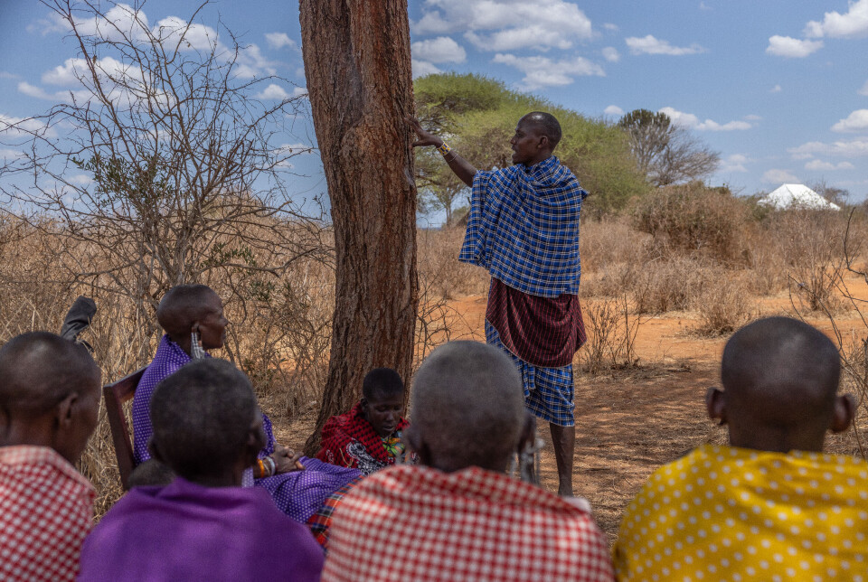 Karbonambassadør Kalanga Osimanjiroi snakker med en kvinnegruppe om hvordan beskyttelse av skogen gir fordeler som bedre regnforhold, tilgang til beite og forebygging av naturkatastrofer.