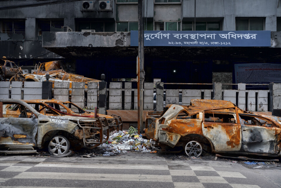 Vrakene av biler som ble tent på under demonstrasjonene i sommer står igjen foran departementet for krisehåndtering og nødhjelp i Dhaka.
