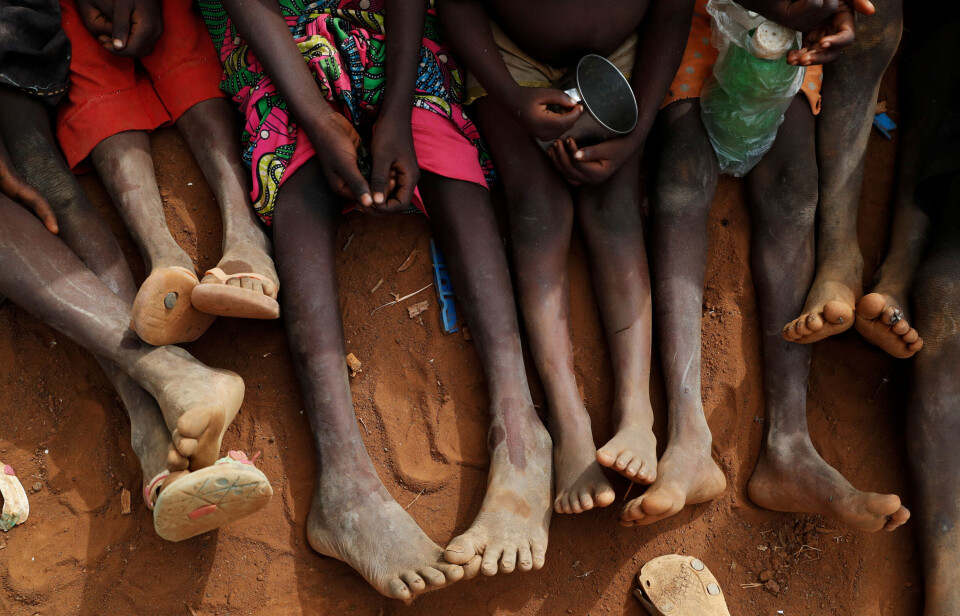 Foreldreløse barn og barn som er skilt fra foreldrene sine er samlet for å spise kokte blader i en leir for internt fordrevne i Nubafjellene i Kordofan, Sudan, 22. juni 2024.