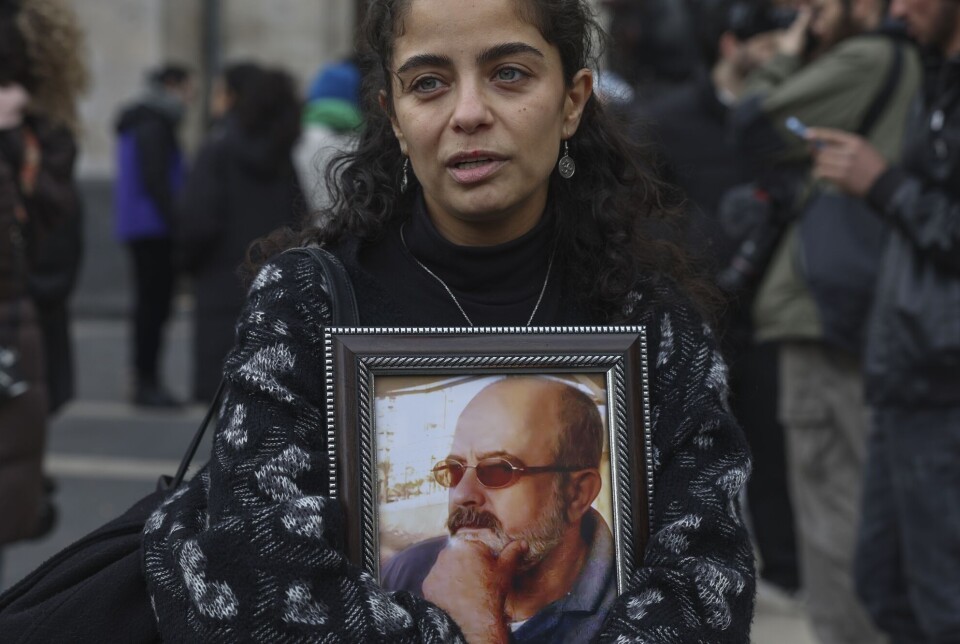 Journalisten Wafaa Mustafa holder rundt et bilde av faren sin under en demonstrasjon i Damaskus i desember.