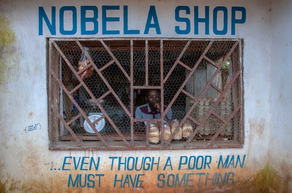 En selger håper at noen vil kjøpe de fire brødene samt eggene og eplene hans i Lilongwe, Malawi.