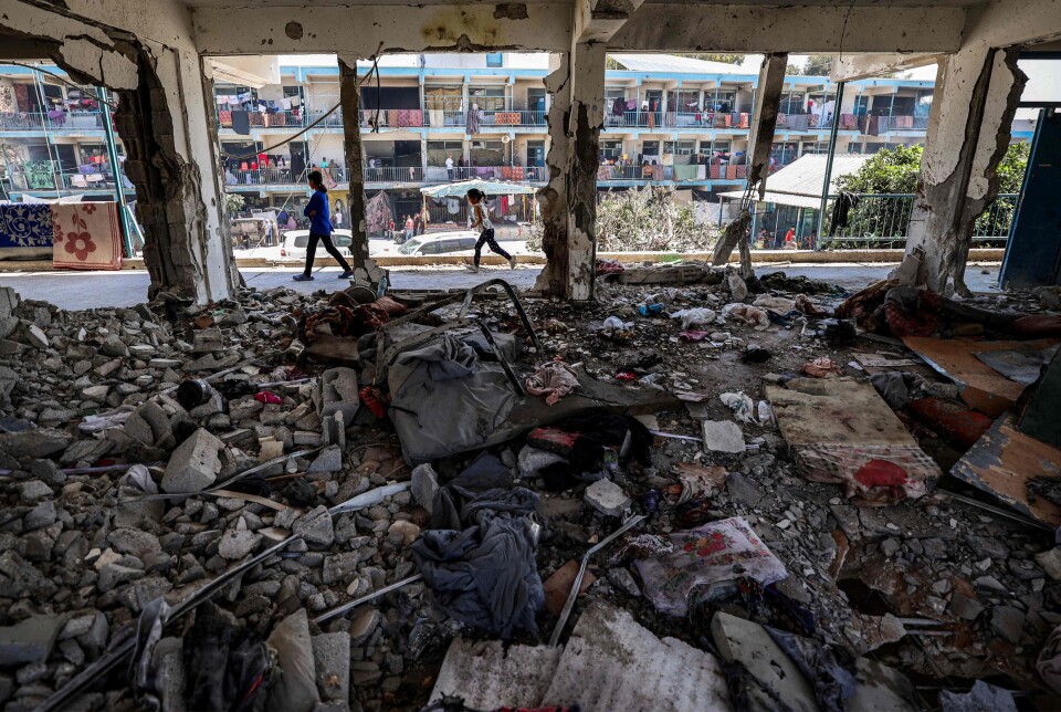 To barn går forbi et ødelagt klasserom på en UNRWA-skole i Nuseirat-leiren på Gazastripen.