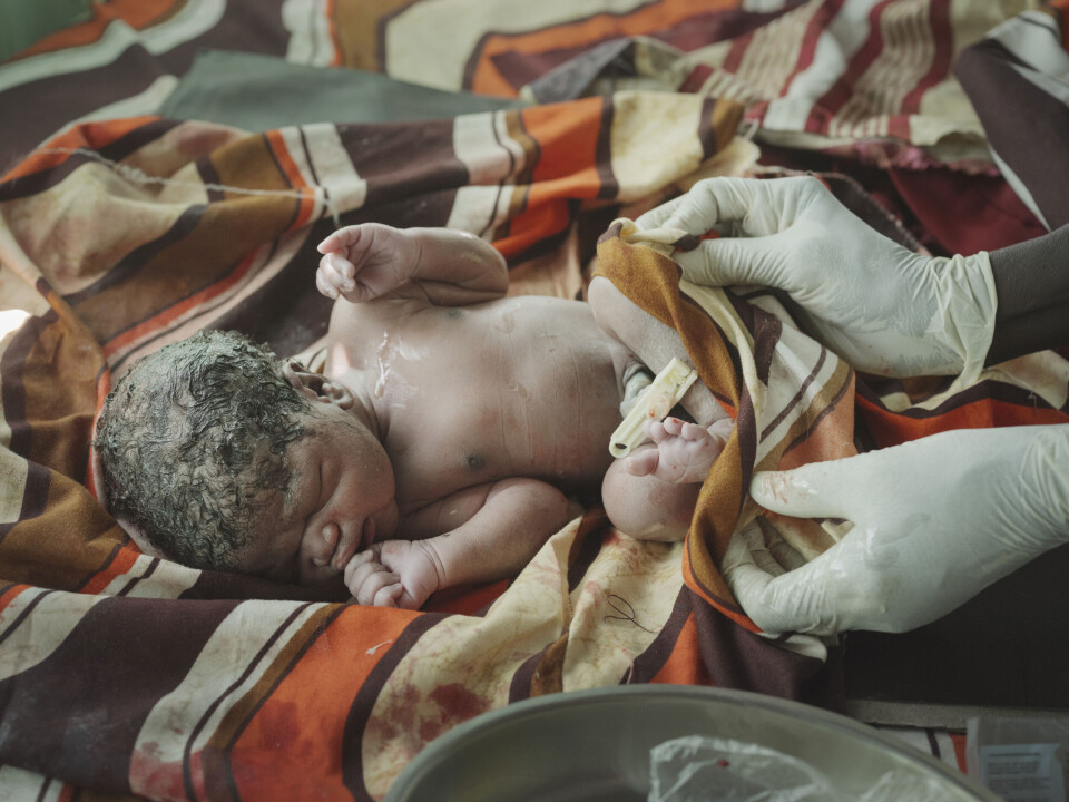 Den fem minutter gamle gutten som ennå ikke har fått navn, blir vasket og stelt av jordmoren.