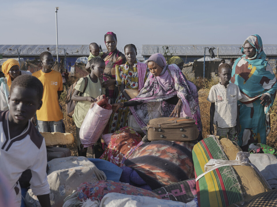 Nyankomne til transittleiren i Renk forsøker å finne bagasjen sin.